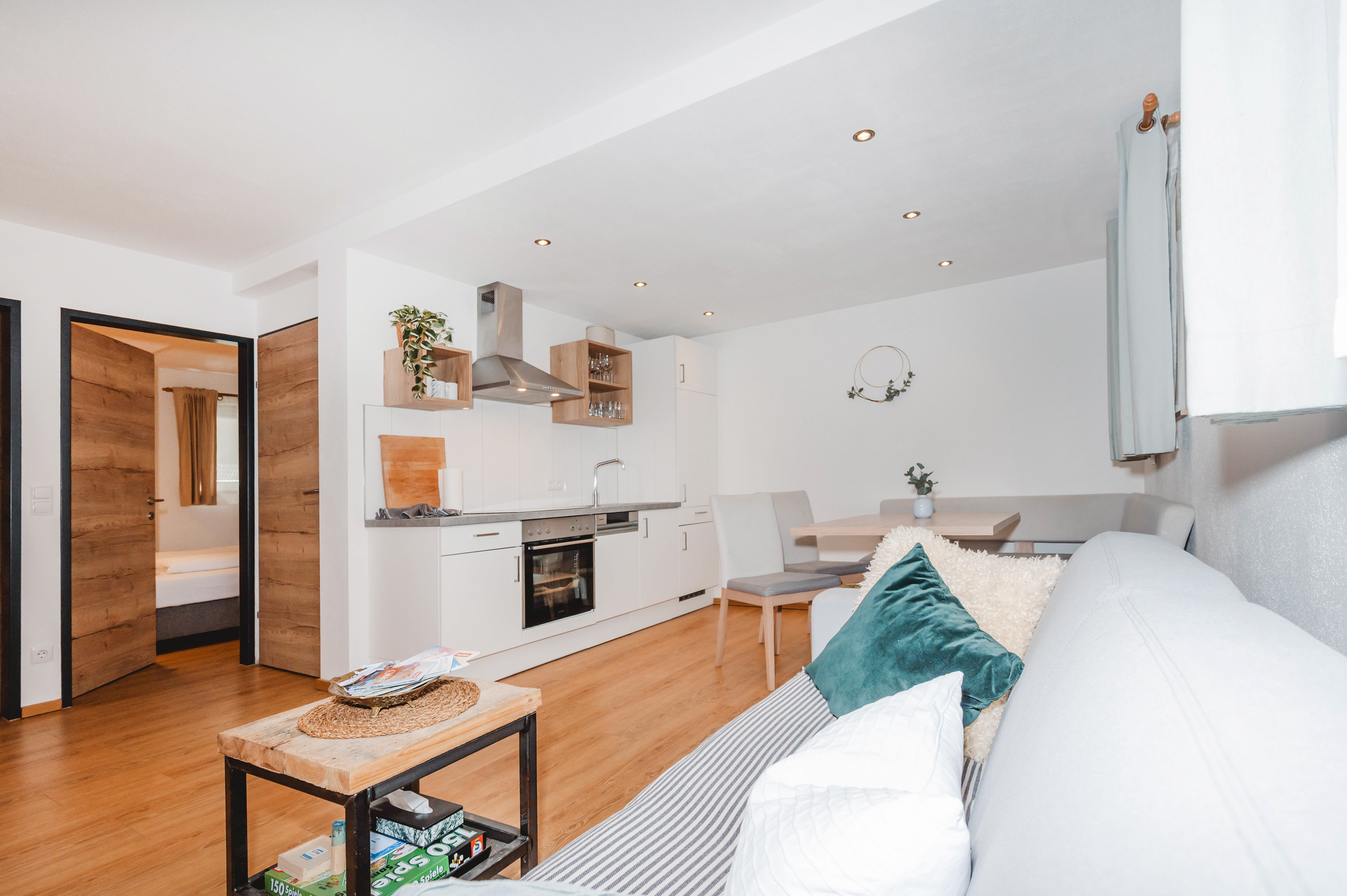 Heller Wohnbereich mit Sofa und Küchenzeile im Souterrain Apartment 333 in Flachau